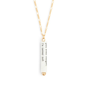 A gold chain necklace with a white scroll charm. The scroll has a saying from Virginia Woolf.