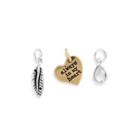 A set of three different gold and silver charms about being in the heart.