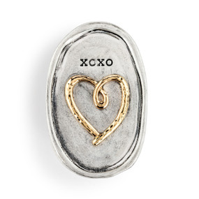 An oval silver metal visor clip with the image of a heart in gold and the saying "XOXO".
