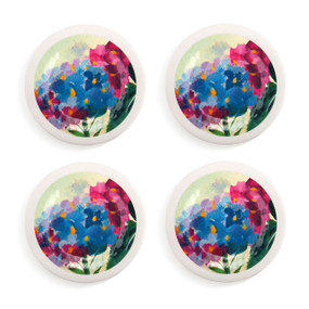 A set of four white appetizer plates with pink and blue hydrangea on them.