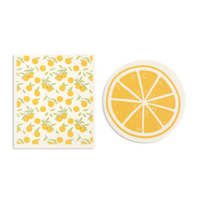 Two orange and white biodegradable dish cloths. One is round and looks like a sliced orange and the other is illustrated oranges.