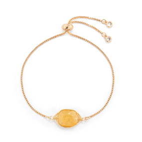 A gold chain adjustable bracelet with a yellow stone charm.