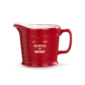 A red ceramic liquid measuring cup with a white interior and the saying "Cupful of Merry" on the front.