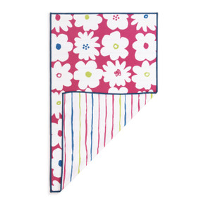 A rectangular double sided towel. One side is dark pink with illustrated large white flowers and the other is white with colorful lines, displayed with the white corner turned back.