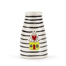 A white ceramic vase with black horizontal stripes and a raised little yellow house with a red heart on the roof.