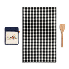 A set of kitchen accessories including a black and white plaid towel, a wood spatula and a blue and cream hot pad with a watercolor image of songbirds.
