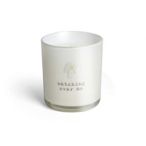 A white glass candle that says "watching over me" and has a small white angel holding a yellow heart on the front.