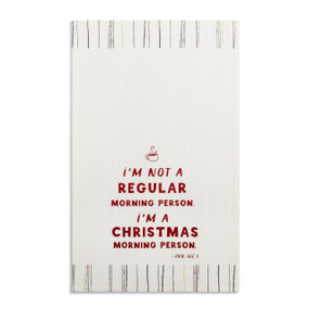A white kitchen towel with the saying "I'm not a regular morning person I'm a Christmas morning person" displayed laid out flat.