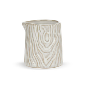 A very small white ceramic pitcher with a wood grain appearance.