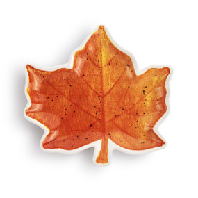 A small maple leaf shaped ceramic plate painted on the inside to look like a fall leaf.