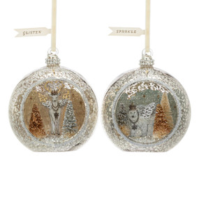 Two silver round open glass ornaments with gold and silver glittery scenes inside. One has a deer and the other a polar bear.