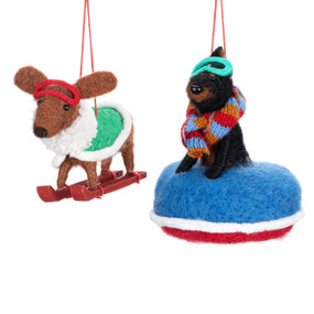 Two different felt dog ornaments including a dachshund and a doberman. One is on skis and the other a snow tube.