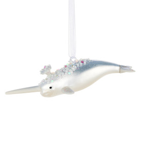 A silver narwhal shaped ornament decorated with white beads and glitter.