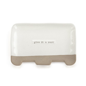A rectangular cream ceramic double spoon rest with the saying "give it a rest".