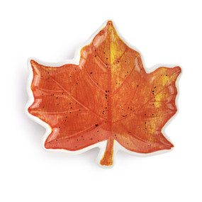 A maple leaf shaped ceramic plate painted on the inside to look like a fall leaf.