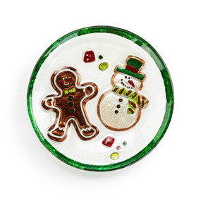 A mini round glass plate with images of a snowman and gingerbread man and a green rim.
