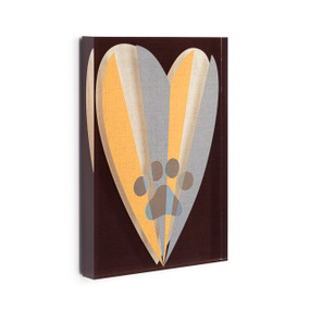A black acrylic wall art tile with a paw print inside a heart in blue, orange and cream displayed angled to the right.