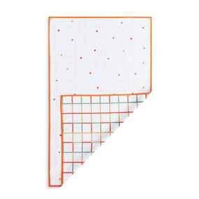 A rectangular double sided towel. One side is white with polka dots and the other is white with multicolored lines, displayed with the lined corner turned back.