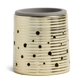 A round gold ceramic wax melter with a gray silicone dish.