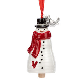 A small white bell shaped like a snowman wearing a red scarf and has a silver metal bird charm at the top.