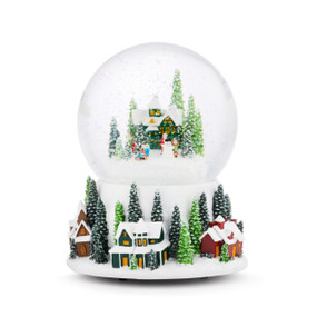 A musical snow globe with a base made out of snowy houses and tall snowy evergreens. The round top has another snowy house and evergreen trees.