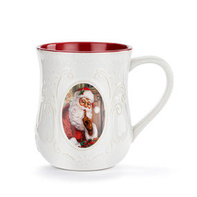 A white ceramic mug with a classic image of Santa Claus on the front. The mug has a red interior.
