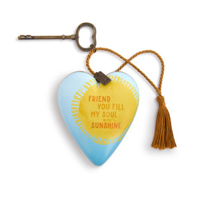 A light blue heart shaped sculpture with a yellow sun and the saying "Friend you fill my soul with sunshine". The heart has a metal key and gold tassel.