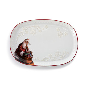 A white oval platter with a red rim, decorative white snowflakes and an illustration of Santa with his bag of toys in the corner.