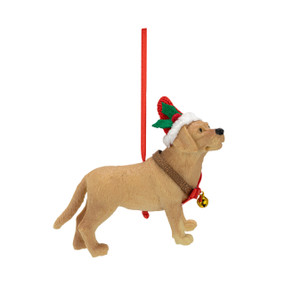 A sculpted ornament of a golden retriever wearing a santa hat and a gold bell around its neck.