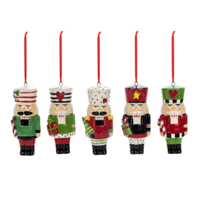 A set of five small ceramic nutcracker ornaments each slightly different in red, green and white.
