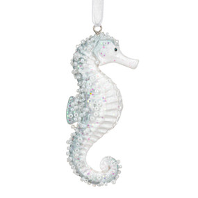 A sea horse ornament made out of light blue and clear glass.