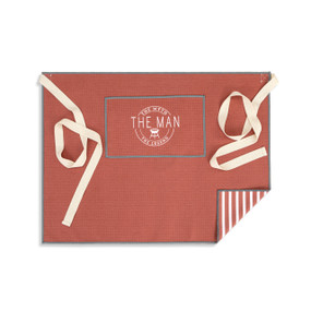 A red and white half apron with cream ties and a pocket with the saying "The Myth The Man The Legend".