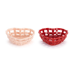 A set of two open weave heart shaped ceramic baskets. One is red and the other is pink displayed at an angle to show depth.