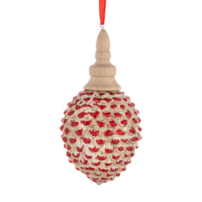 A wood carved ornament shaped like a pinecone with red painted on the tips.