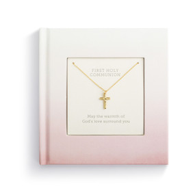 A small square pink inspirational first holy communion book with a gold cross necklace inside.