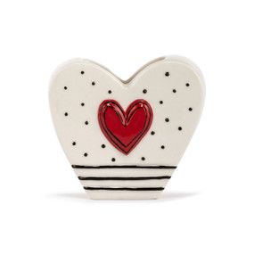 A white heart shaped ceramic vase with black stripes and a red heart on the front.