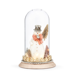 A clear glass lit cloche figure with a snowman inside holding a gold sparkly tree. The figure is decorated with sparkle and beads.