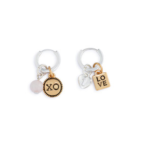 A pair of silver hoop earrings with four different charms related to love.
