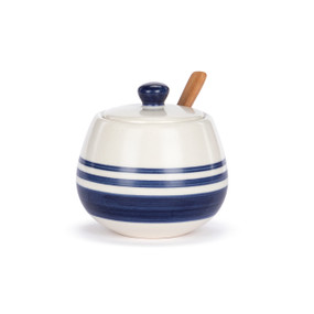 A white ceramic condiment dish with blue stripes, a lid and wood spoon.