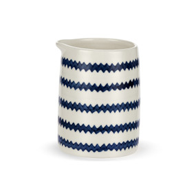 A small white ceramic pitcher with dark blue zig zag stripes and no handle.