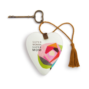 A white heart shaped sculpture with an illustrated colorful rose and the saying "Super Woman Super Mom". The heart has a metal key and gold tassel.