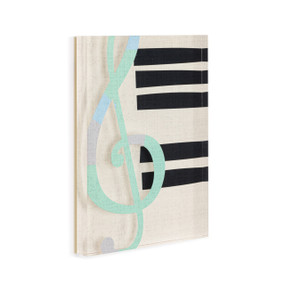 A cream acrylic wall art tile with an illustrated green treble clef and black keys like a piano displayed angled to the right.