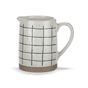 A mini white ceramic pitcher with dark blue thin plaid lines and a tan textured base.