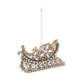 An ornately decorated sleigh shaped ornament decorated with gold glitter and silver beads.