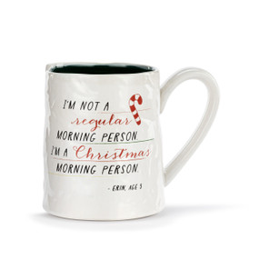 A white ceramic mug with a crinkly appearance. The interior is black and the saying "I'm not a regular morning person. I'm a Christmas morning person" is on the front.