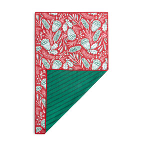 A rectangular double sided towel. One side is red with illustrated pinecones and the other is green stripes, displayed with the green corner turned back.