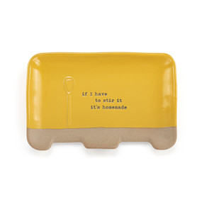 A rectangular yellow ceramic double spoon rest with the saying "if I have to stir it it's homemade".