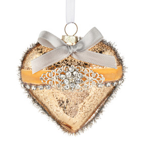 A heart shaped gold ornament decorated with silver beads, gold ribbon and tinsel.