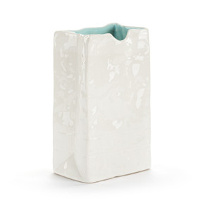 A small white ceramic vase that looks like a crinkly paper bag with a light blue interior.