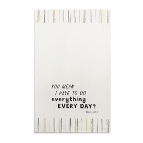 A white kitchen towel with the saying "You mean I have to do everything every day?" displayed laid out flat.
